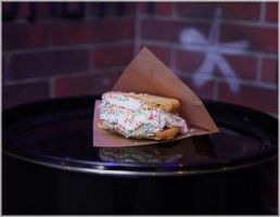 Chewy cookie sandwich met ijs en slagroom, gerold in Damonsta-toppings. Streetstyle dessert en monsterlekker!